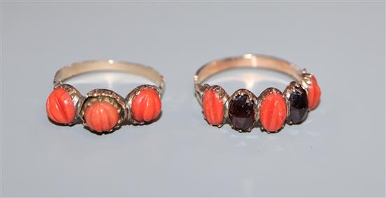 Two Georgian yellow metal and carved coral set half hoop rings, one set with coral and garnet.